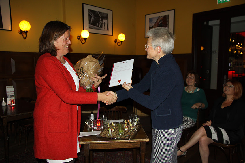 Foto van Marijke van Grafhorst, voorzitter NKD, die het eerste certificaat uitreikt aan Marian Ruitenberg, manager Driestar Educatief